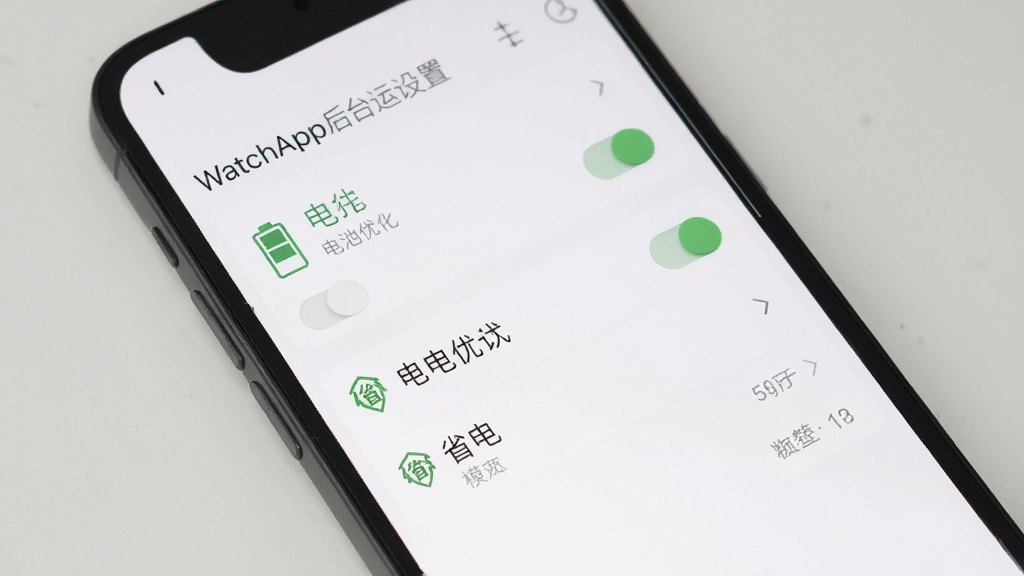 WatchApp后台运行设置界面,主体为手机屏幕展示电池优化选项,布局为列表式排列,排版简洁,风格为极简素雅风,细节包含电池图标、开关按钮、省电模式标识,画质高清,干净,无多余元素