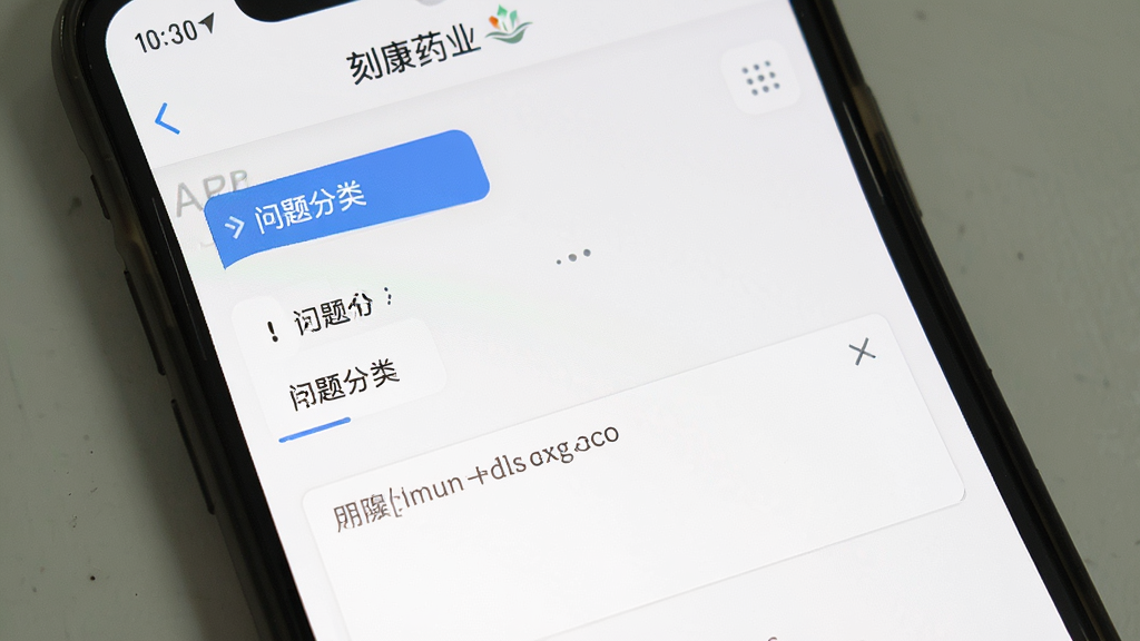 手机屏幕截图,展示“刻康药业”APP的帮助与反馈页面,包含问题分类选项和文字输入框,背景为白色,界面简洁,风格为扁平化设计,画质清晰,无多余元素