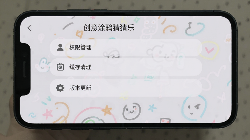 手机屏幕展示创意涂鸦猜猜乐的设置界面,有权限管理、缓存清理、版本更新等选项,界面简洁明了,背景为浅灰色,风格实用简约,画质清晰干净,画面中带有