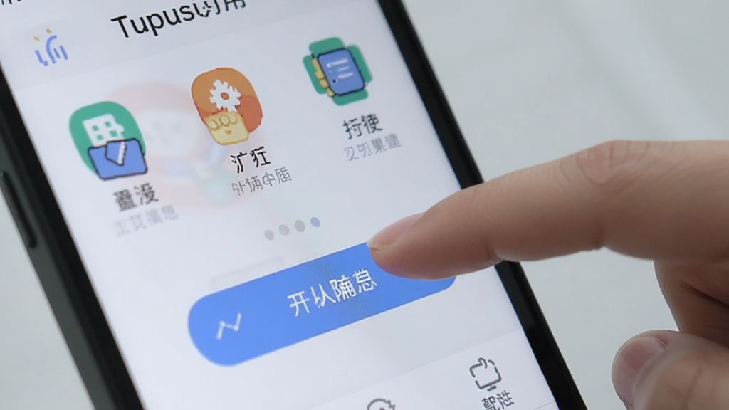Tupusi应用界面特写,展示清晰的图标排列和中文菜单标签,一只手正在点击屏幕上的功能按钮,背景为柔和浅灰色,突出操作简单的特点,画面整洁