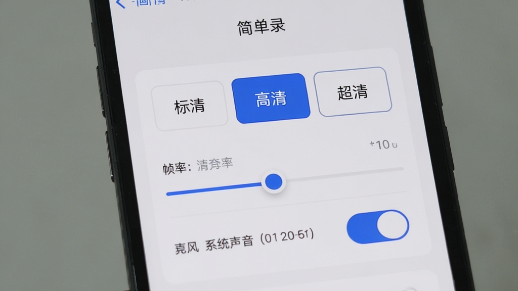 手机屏幕展示“简单录”的画质设置页面,页面上排列着“标清”“高清”“超清”三个选项按钮,下方有帧率调节滑块和麦克风、系统声音的开关按钮,界面采用卡片式布局,浅灰底色配蓝色高亮选中状态,风格现代简洁,画质清晰