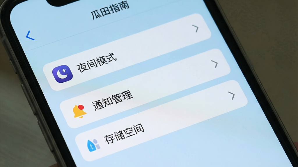 瓜田使用指南界面,手机屏幕显示设置菜单,包含“夜间模式”、“通知管理”、“存储空间”等选项,背景为浅蓝色,布局清晰,风格简洁,细节明确,画质高,干净,无多余元素。