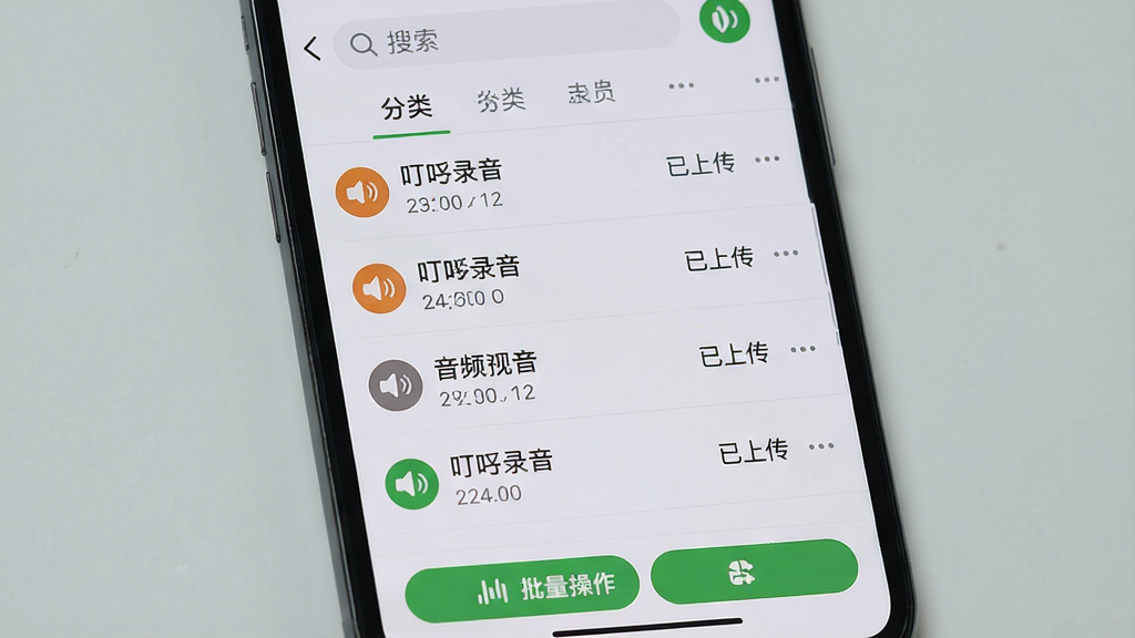 主体:手机屏幕显示叮咚录音的文件管理界面,以列表形式展示多个音频文件,每个文件带有时间、大小标签。布局:竖屏列表布局,顶部有搜索栏和分类标签,底部有批量操作按钮。排版:文件行间距适中,文件名称左侧有音频图标,右侧有更多操作菜单。风格:简洁的列表设计,背景为浅灰色。细节:部分文件已标注为“已上传”状态,文件名称清晰可见。画质:界面渲染清晰,干净无多余元素。