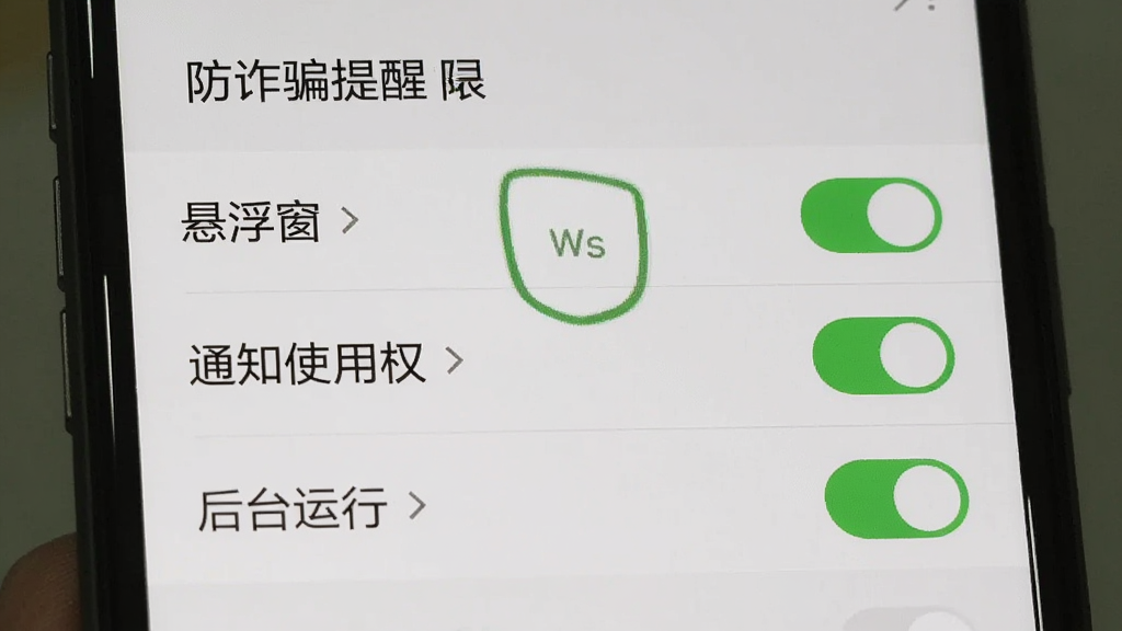 手机设置界面截图,显示“防诈骗提醒”的权限设置页面,包含“悬浮窗”“通知使用权”“后台运行”三个开关,全部处于开启状态,背景为系统设置列表,画面清晰写实,画质干净,无多余元素