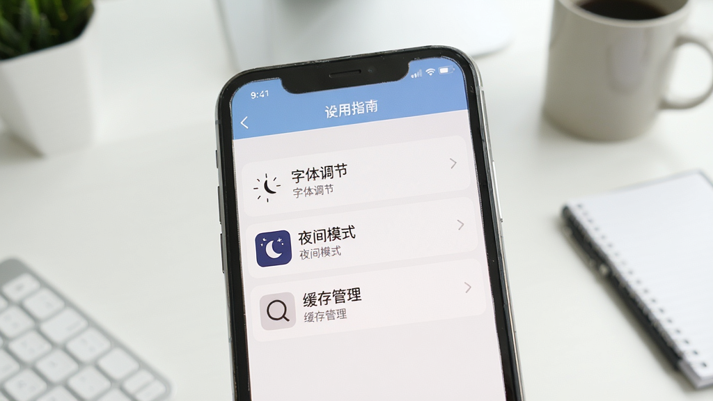 书尖使用指南插图,手机屏幕显示设置菜单,包含字体调节、夜间模式、缓存管理等选项,背景为简洁桌面,风格写实,色彩自然,画质清晰,干净无多余元素