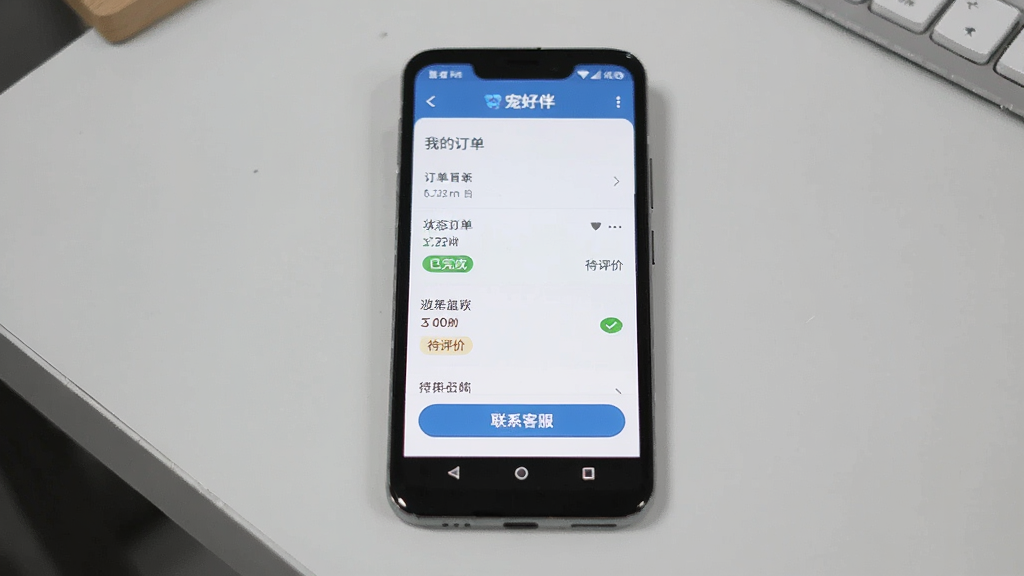 画面主体为一部安卓手机屏幕显示“宠好伴”App的“我的订单”页面,页面底部有“联系客服”按钮;布局采用手机竖屏展示,背景为浅灰色桌面;排版清晰,风格实用;细节包括订单状态“已完成”和“待评价”标签;画质干净清晰,无多余元素。