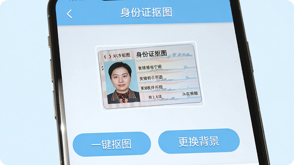 一张手机屏幕截图,展示身份证抠图软件的主界面,界面简洁,上方有“身份证抠图”应用名称,中间展示一张待处理的身份证照片,下方有“一键抠图”和“更换背景”两个醒目的功能按钮,整体风格清爽,浅蓝色调,画质清晰,无多余元素