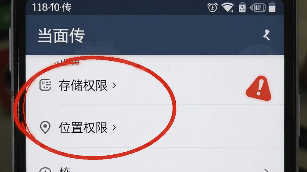 画面展示一部安卓手机屏幕截图风格,界面显示「当面传」的设置页面,其中「存储权限」和「位置权限」两个选项被高亮圈出,旁边有一个红色的感叹号提醒。画面风格为UI界面演示,细节清晰,画质干净,文字为「当面传」