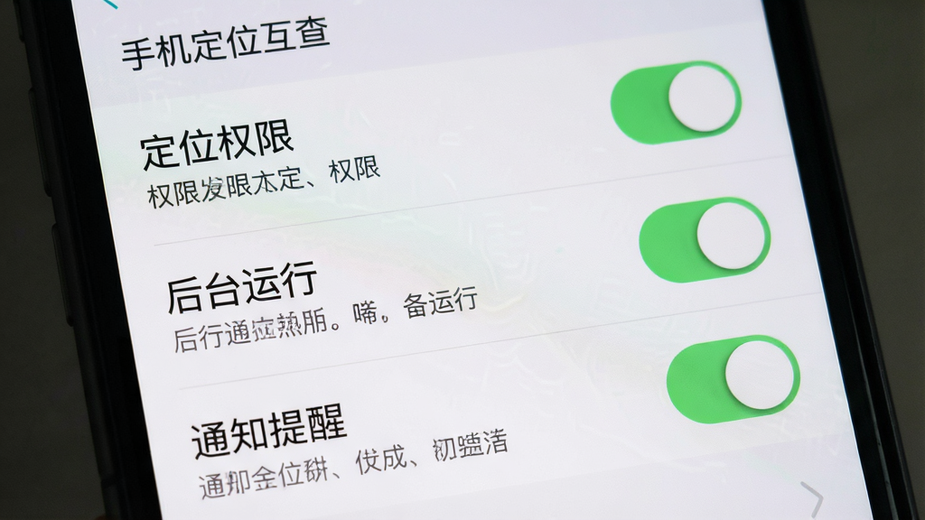 一张手机屏幕展示软件设置界面,界面中包含“定位权限”“后台运行”“通知提醒”等选项开关,每个选项旁边有简短的说明文字,整体布局为竖向列表,采用浅灰质感风格,细节上开关按钮有柔和的绿色高亮,画质干净,无多余元素,图片中文字“手机定位互查”