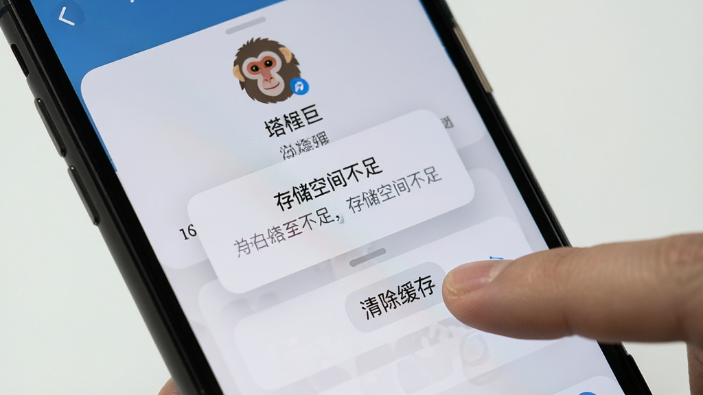 画面展示一部手机屏幕中塔猴应用出现报错弹窗,旁边有手指点击“清除缓存”按钮,布局为手机特写加操作手势,排版聚焦屏幕内容,风格为写实UI截图风,细节上弹窗文字为“存储空间不足”,画质高清,干净,无多余元素