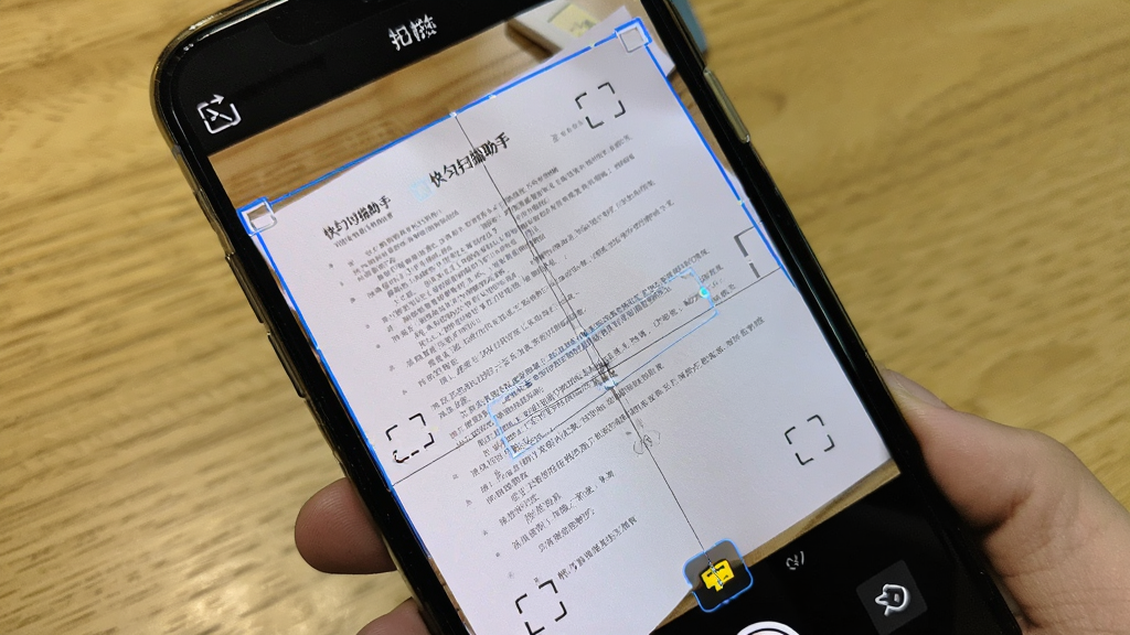 手机摄像头对准一张倾斜摆放的纸质文件,屏幕上
