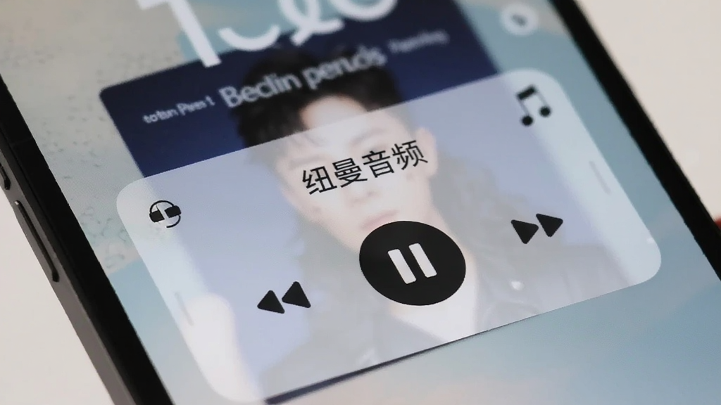 手机锁屏界面显示音乐播放控制卡片,卡片上有
