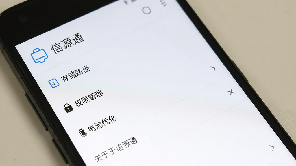 一部安卓手机显示信源通的设置界面,界面中包含“存储路径”“权限管理”“电池优化”“关于信源通”等选项,屏幕上方有“信源通”标题,背景为白色,图标为蓝色线条风格,画质清晰,布局简洁,无多余元素