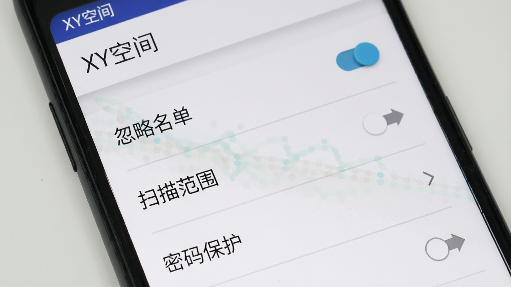 一部安卓手机显示XY空间APP的设置页面,页面中有“忽略名单”“扫描范围”“密码保护”等选项列表,屏幕顶部有“XY空间”字样,风格为简洁设置菜单界面,细节包括开关按钮、箭头图标、灰色分隔线,画质清晰,干净,无多余元素