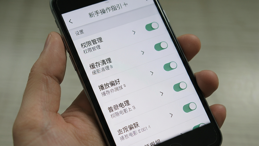 免费电影大全 新手操作指引 主体为手机屏幕 屏幕中显示设置菜单 包含权限管理 缓存清理 播放偏好等选项 布局为纵向列表 风格浅灰质感 细节有开关按钮 箭头图标 文字说明 画质清晰 干净 无多余元素