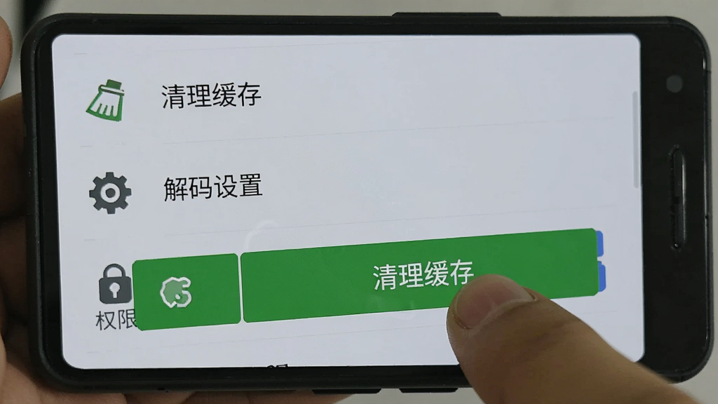 一部安卓手机屏幕显示免费热门短剧的设置界面,界面中有“清理缓存”“解码设置”“权限管理”等选项,手指正在点击“清理缓存”按钮,背景为浅灰色,图标简洁,风格扁平化,画质清晰,干净无多余元素