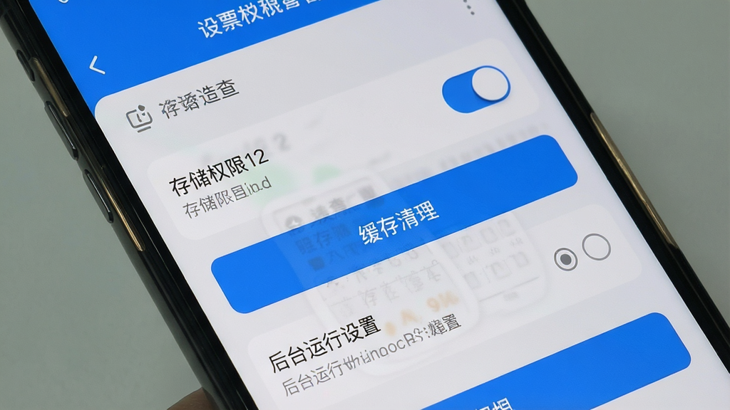 一张手机屏幕展示电子发票税务查查的设置与权限管理页面,画面中包含存储权限开关、缓存清理按钮、后台运行设置选项,界面采用浅灰底色搭配蓝色按钮,风格为简洁移动端设置界面,细节包括开关滑块、图标标识、文字说明,画质清晰,干净无多余元素