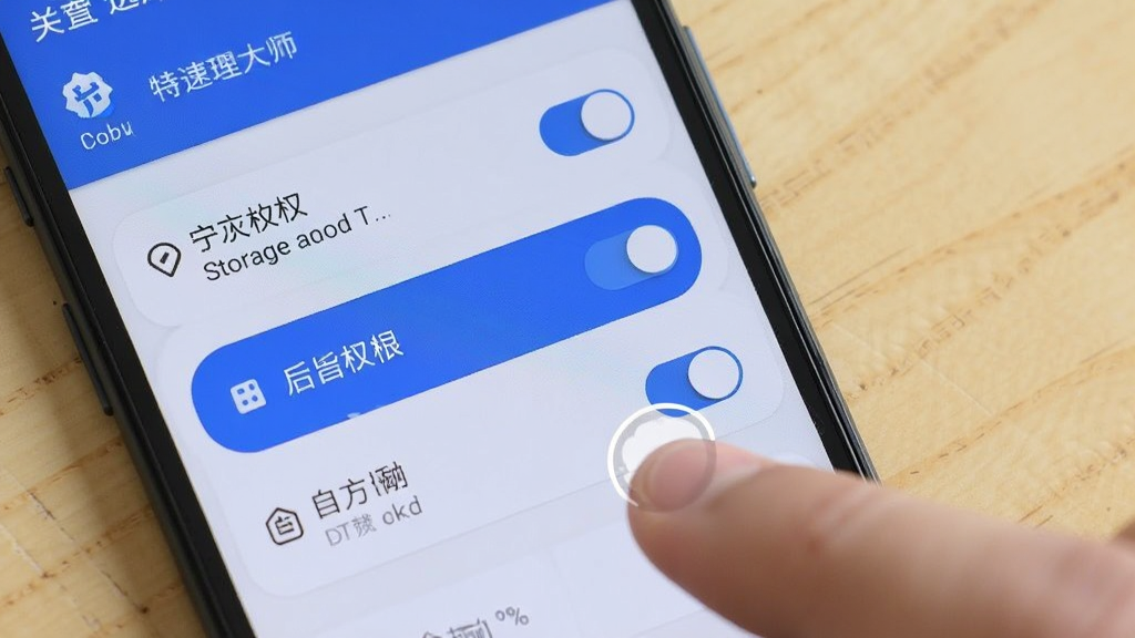 一部安卓手机显示特速清理大师的权限设置界面,界面中有存储权限、后台运行权限、自启动权限三个开关按钮,手机旁边有手指点击屏幕的示意,背景为浅色木质桌面,整体风格生活化且清晰,高清画质。