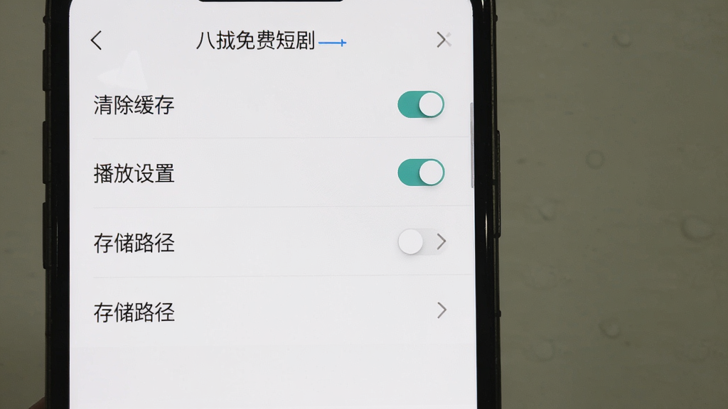 手机屏幕显示八戒免费短剧的设置页面,包含清除缓存、播放设置、存储路径等选项,界面简洁,背景为白色,布局为分组列表,风格为实用设置界面,细节包含开关按钮和箭头图标,画质高清,干净,无多余元素
