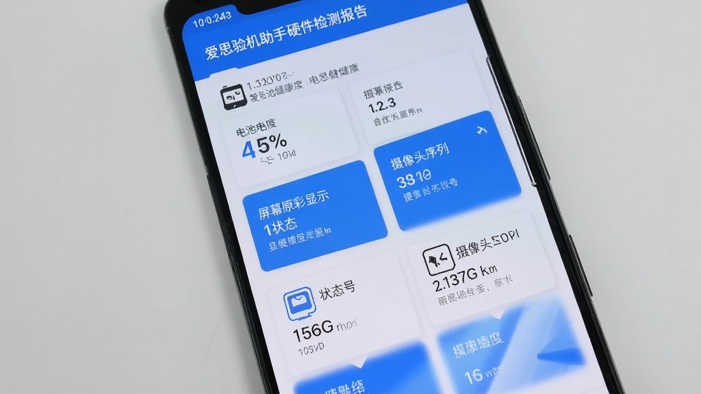一部安卓手机屏幕显示爱思验机助手的硬件检测报告页面,报告中包含电池健康度百分比、屏幕原彩显示状态、摄像头模组序列号等多项数据,界面采用卡片式布局,蓝白配色,背景为浅灰色,画面干净整洁,无多余元素,画质高清。