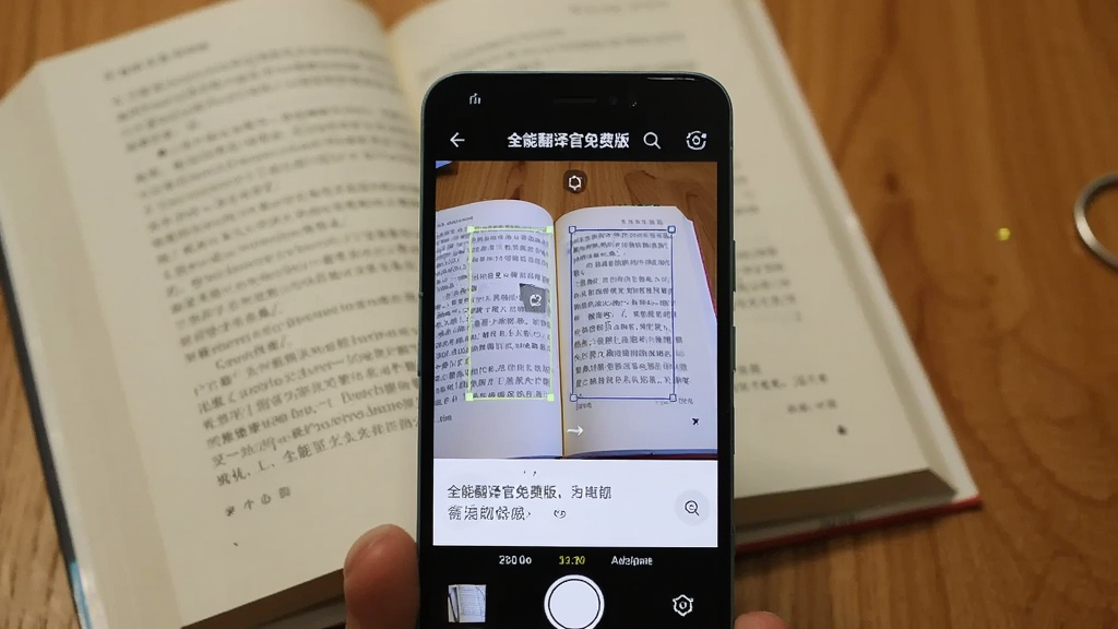 一部安卓手机正在拍摄一本打开的外文书籍,手机屏幕上显示