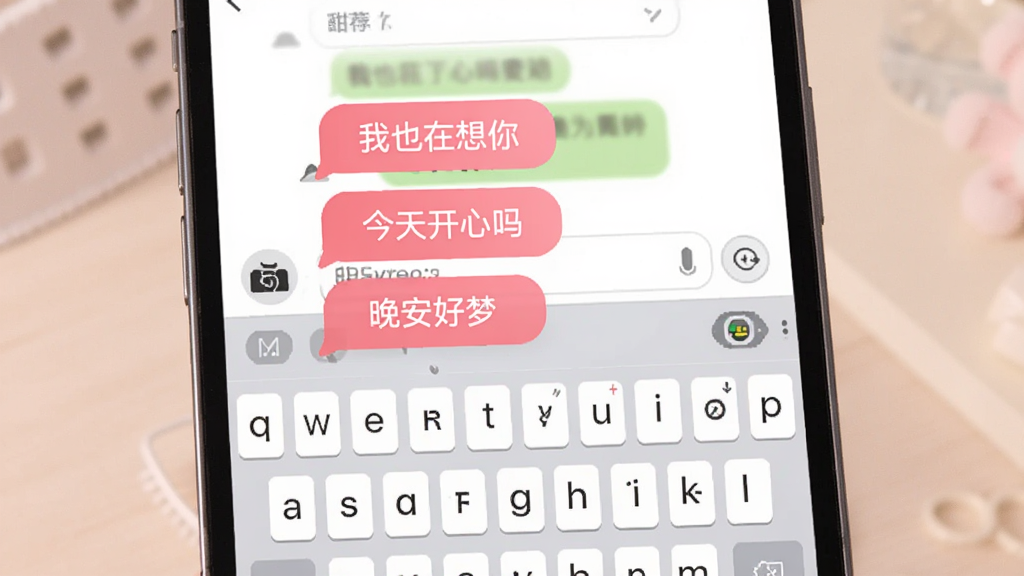 一张展示甜恋键盘智能回复推荐功能的界面图,画面中手机屏幕显示聊天窗口,键盘上方出现三条粉色推荐回复气泡,分别写着“我也在想你”“今天开心吗”“晚安好梦”,整体布局简洁,风格柔和,画质清晰,无多余元素