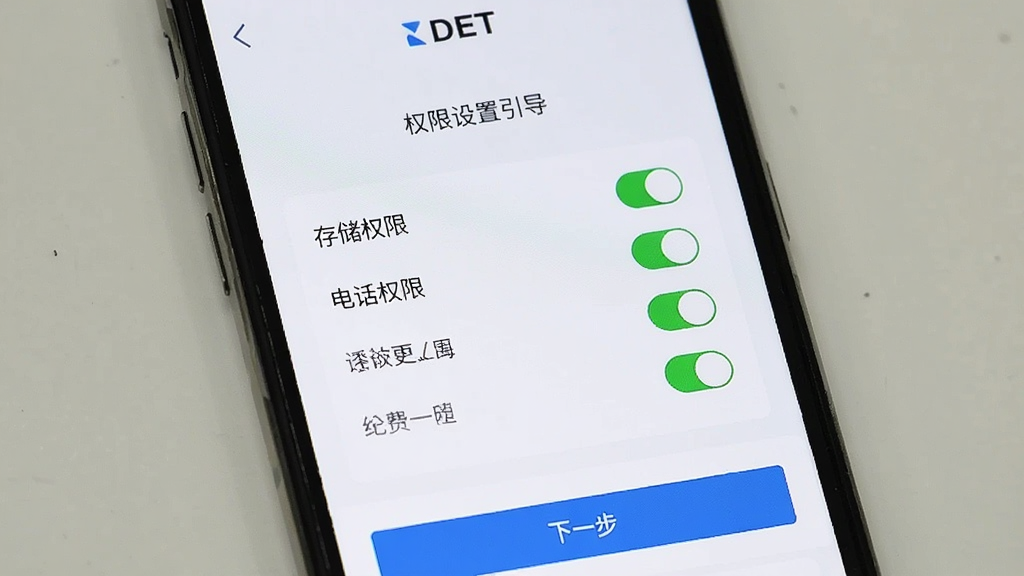 一部手机屏幕上显示DET软件的权限设置引导页面,页面中有存储权限、电话权限等选项开关,界面底部有“下一步”按钮,背景为白色,风格简洁明了,画质清晰,软件名称“DET”显示在顶部